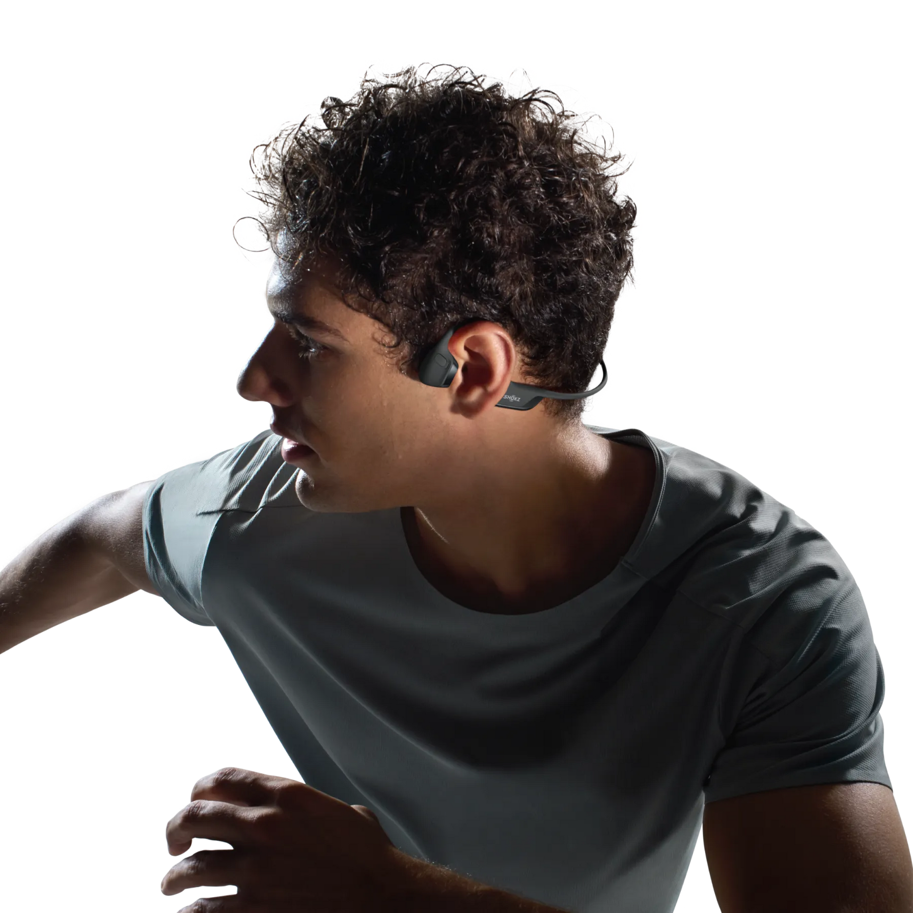 Man wearing Shokz bone conduction headphones while exercising in athletic shirt