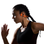 Woman wearing orange Shokz bone conduction headphones during workout, showing open-ear design