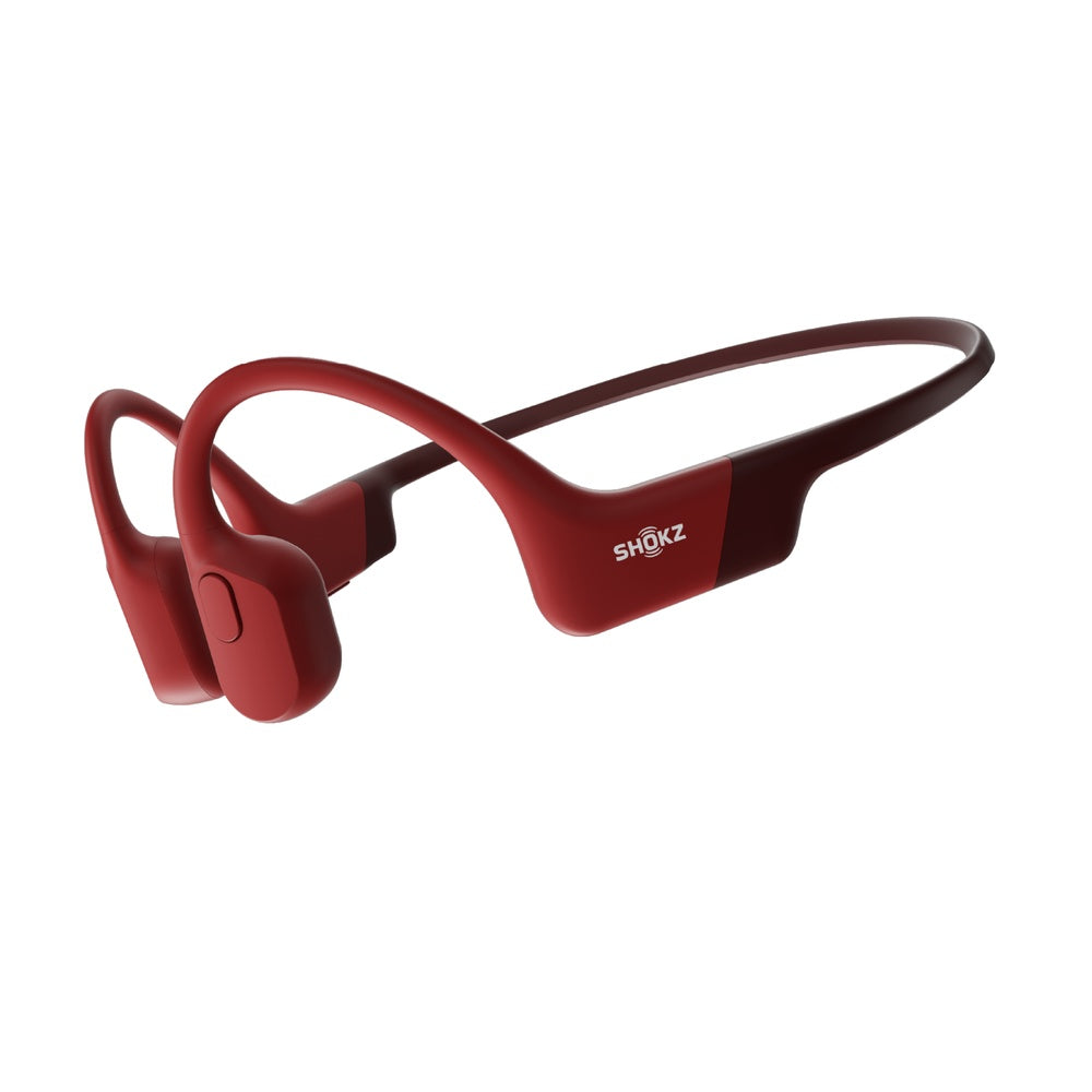 Red Shokz bone conduction headphones with wraparound design on white background