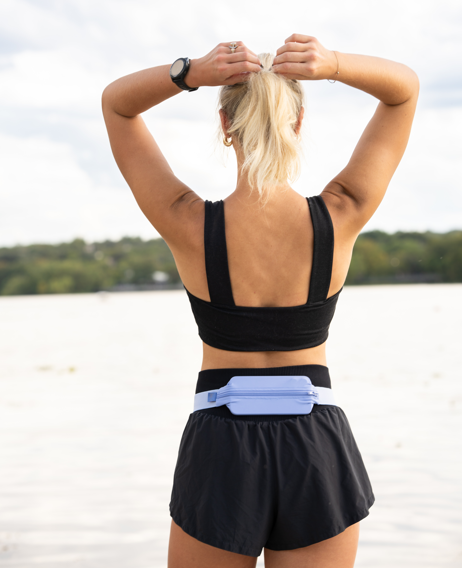 Female athlete wearing SPIbelt Monochromatic Pro Belt in Space Blue at waterfront