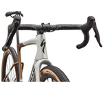 Specialized Crux Expert gravel bike front end detail showing handlebars and fork in Dolomite White and Burnt Gold