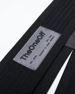 TheOneOff Xenon Bib Short close-up showing brand label on black ribbed fabric