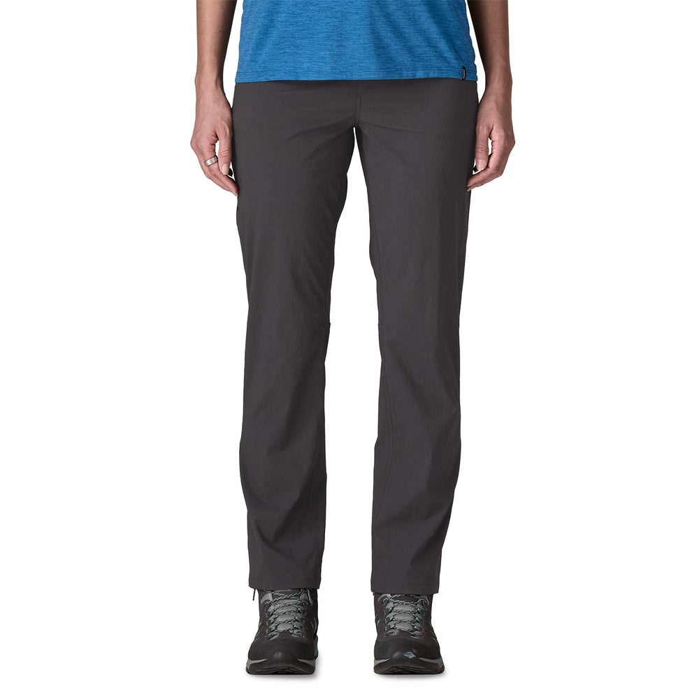 Woman wearing dark gray Patagonia Quandary pants with blue top and hiking shoes