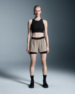 Woman wearing On 3-inch Performance 2-in-1 shorts in Cinder Black with black crop top