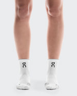 On Performance Run Sock Mid Unisex in white with glacier trim worn on model legs