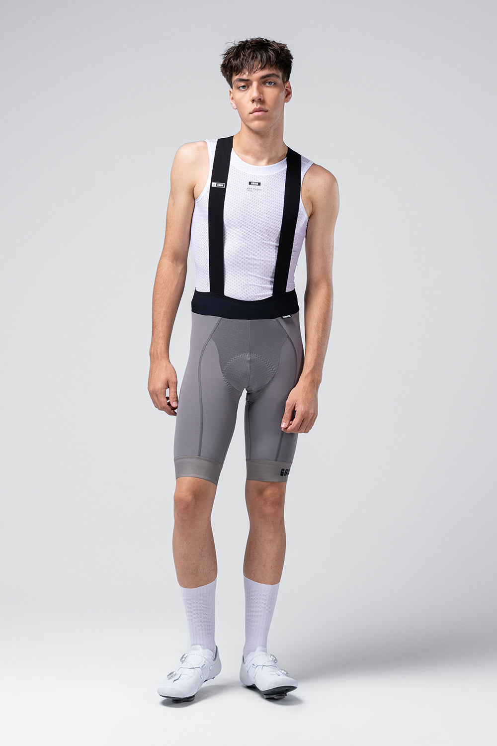 Male cyclist wearing gray Gobik Absolute 7.0 bib shorts with white jersey and socks