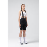 Woman wearing black Gobik X bib shorts with white sports bra in studio