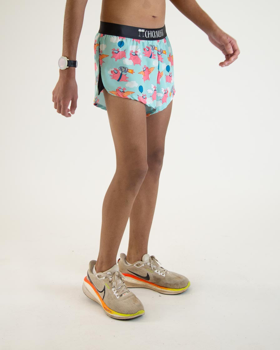 ChicknLegs men's split running shorts with flying pigs pattern on light blue background