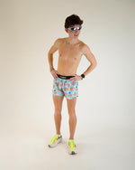 Man wearing ChicknLegs Flying Pigs patterned running shorts in teal with colorful pig design