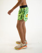 Man wearing bright green athletic shorts with pickle pattern and black waistband