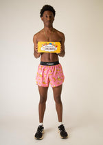 Man wearing pink shorts with banana pattern holding ChicknLegs product box