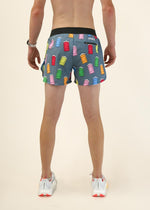 Man wearing ChicknLegs shorts with colorful milk carton print on dark background
