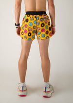 Back view of yellow running shorts with colorful donut pattern on model