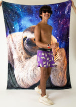 Man wearing purple ChicknLegs sloth pattern shorts against space-themed backdrop