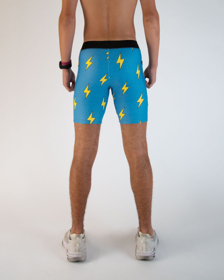 Man wearing blue athletic shorts with yellow lightning bolt pattern, rear view