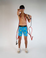 Man wearing blue shorts with yellow lightning bolts against white studio background