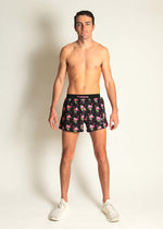 Male model wearing ChicknLegs black flamingo print 4-inch half split running shorts