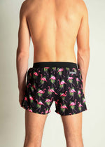 Back view of male model wearing ChicknLegs black flamingo print 4-inch half split running shorts