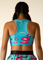 Back view of woman wearing ChicknLegs turquoise sports bra with pink flamingo print