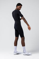 Male athlete wearing black Gobik Integral Hudson cycling suit with white shoes