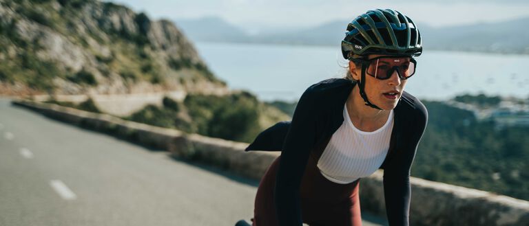 Cyclist wearing black Kask Valegro helmet while riding on scenic mountain road