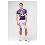 Male cyclist modeling Gobik CX Pro 4.0 violet jersey with white bib shorts full body front view