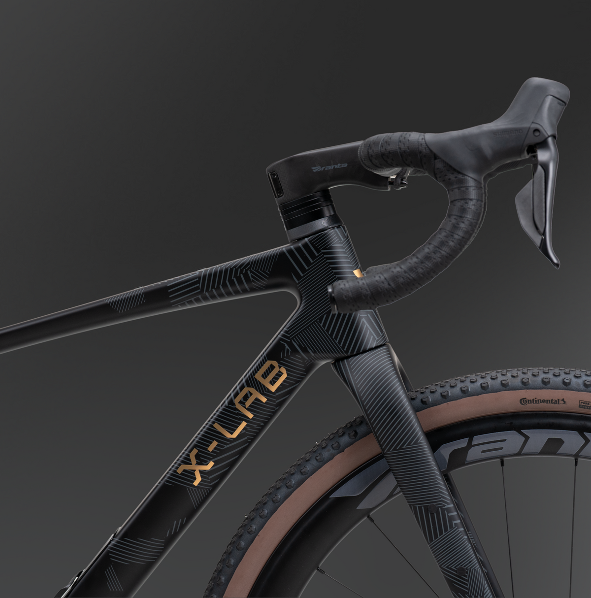 Close-up of X-LAB GT8 head tube and handlebars showing black geometric pattern and gold branding