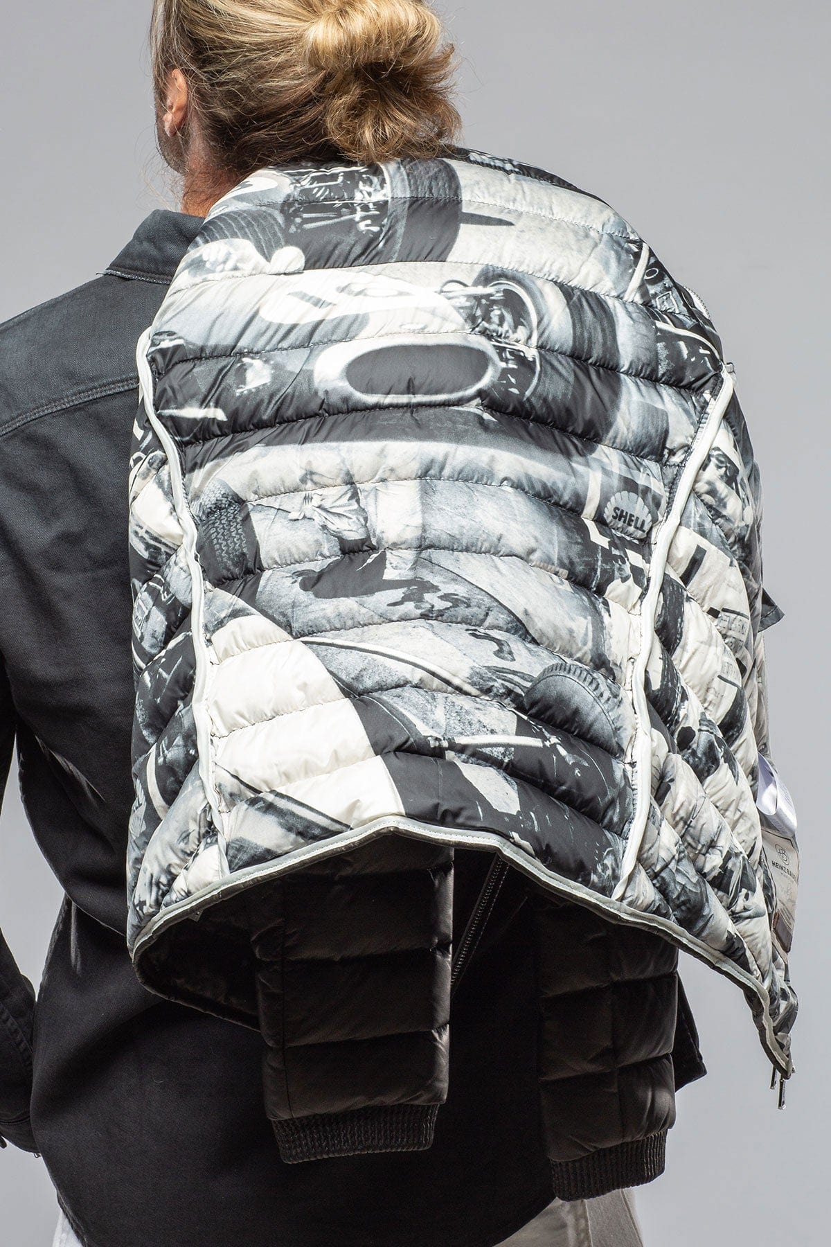 Dakine quilted backpack with black and white motorsport photo print worn on model