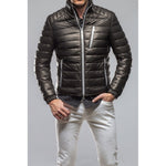 Men's black quilted puffer jacket with silver zippers worn over white pants