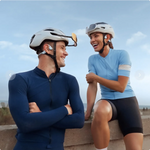 Two cyclists wearing white Shokz OpenRun Pro bone conduction headphones outdoors