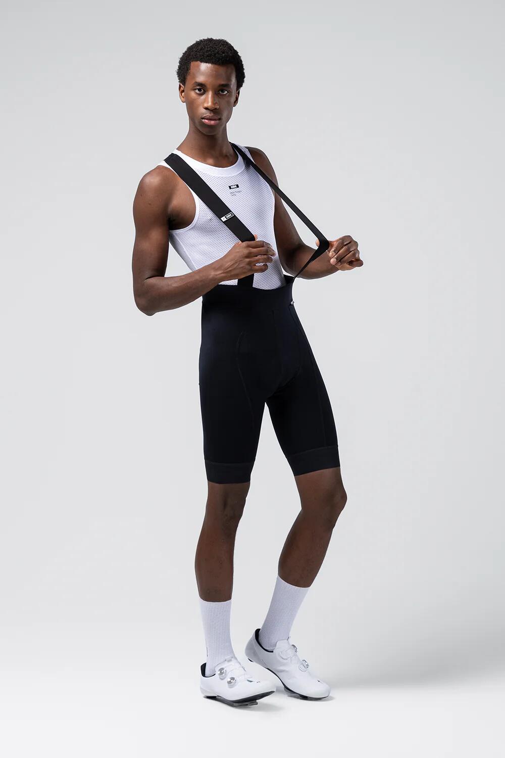Male cyclist wearing Gobik black bib shorts with white base layer, front three-quarter view