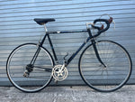 Classic drop handlebars with newer black bar tape on vintage Peugeot road bike