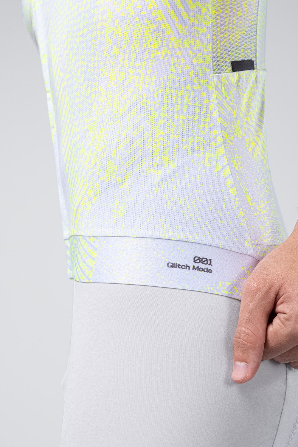 Gobik CX Pro 4.0 cycling jersey hem detail showing Glitch Mode 001 label in neon yellow pattern