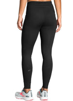 Woman wearing black Brooks Momentum Thermal Tights showing back view and leg fit